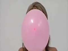 Teen blows to pop pink balloons